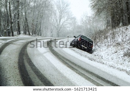 Abandoned car in the ditch after the traffic accident. Symbolises the dangerous conditions in winter with ice, snow and snatch. 