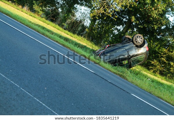 Abandoned car in the ditch after the traffic accident.\
Lying on the roof. 