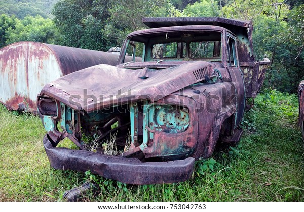 Abandoned car leaving in the forest. Wreckage car\
with rust.