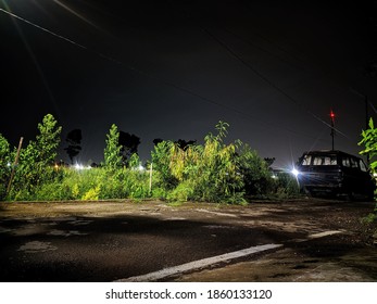 Abandoned Car Wrecked In Front Of Rice Fields At Night