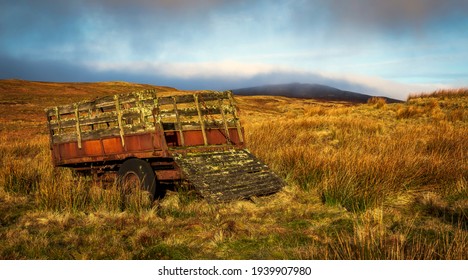 Am Abandoned Cart Sits Beside A Farm Track While The Morning Light Warms The Moor Around It.