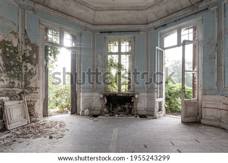 Abandoned castle, room with fireplace and large broken windows