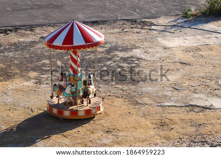 abandoned children's carousel in a vacant lot.
