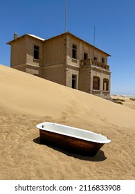 Abandoned City Of Kolmanskop In Namibia. Ancient City Covered With Sand In The Desert Of Africa. Diamond Mine. Ghost Town. Old Ruin In Dunes Outdoors. Bath Tub Outside.