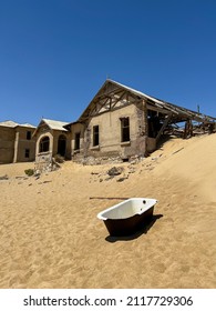 Abandoned City Of Kolmanskop In Namibia. Ancient City Covered With Sand In The Desert Of Africa. Diamond Mine. Ghost Town. Old Ruin In Dunes Outdoors. Bath Tub Outside.