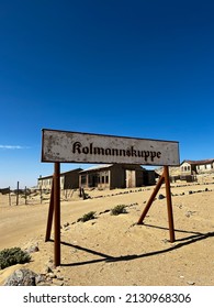 Abandoned City Of Kolmanskop In Namibia. Ancient City Covered With Sand In The Desert Of Africa. Diamond Mine. Ghost Town. Road Sign Kolmannskuppe. SUV Car.