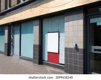 Abandoned Closed High Street Bank Or Store Front With Boarded Up And Covered Windows