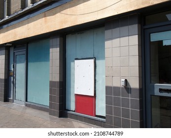 Abandoned Closed High Street Bank Or Store Front With Boarded Up And Covered Windows