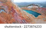Abandoned copper mines of Cyprus. Colorful gossan (iron cap) of Alesto mine with open pit filled with water, and Memi mine lake at the distance