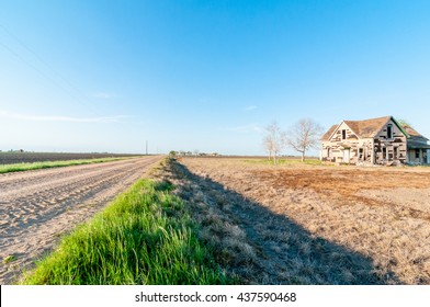 An Abandoned And Decaying House Along A Dirt Road In The Country Side In Rural Texas On A Bright, Summer Day. 