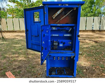 Abandoned Electrical Control Panel with Open Doors in Outdoor Environment. 