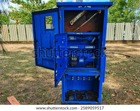 Abandoned Electrical Control Panel with Open Doors in Outdoor Environment. 