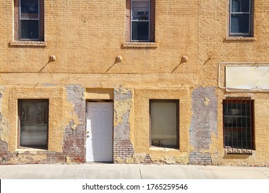 an abandoned empty business shop building front with vintage yellow brick wall