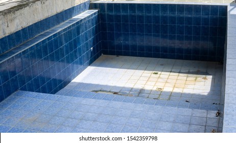 An Abandoned And Empty House Swimming Pool Under A Roof During The Day. No Water Filled In The Pool Because Of The Piping Problem.