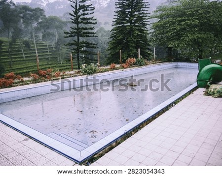 abandoned and Empty Swimming Pool with Slide in Misty Mountain