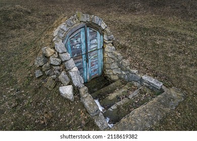 Abandoned Entrance Door To Dungeon Or Basement. Perspective View Of Closed Peeled Wooden Doors Cellar In Ground