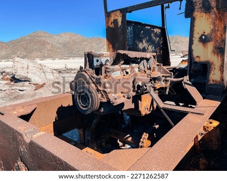Abandoned equipment with the elements taking over. Natural earth recouping its land as the manmade objects deteriorate. Rusting and crumbling back into dirt. Abandoned by a shut down business and left