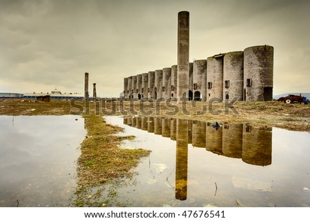 Abandoned facility under moody cloudy dark sky, image of decrepitude