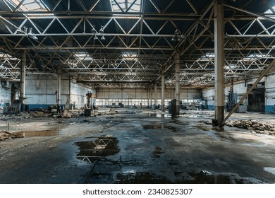 Abandoned factory. Large empty ruined industrial hall with broken remnants of equipment.
