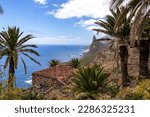 Abandoned farm house and tropical palm trees with panoramic view on Roque de las Animas crag in the Anaga mountain range, Tenerife, Canary Islands, Spain, Europe. Hiking trail from Afur to Taganana