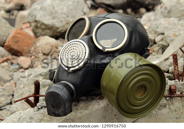 Abandoned gas\
mask. The mask is lying on the\
stones