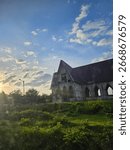 "Abandoned half-built structure standing under a clear blue sky."