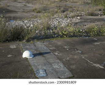 Abandoned hard hat on patch of derelict land, formerly a steelworks, West Midlands, UK