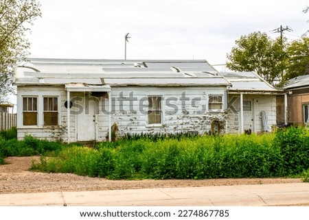 Abandoned Home In Disrepair And With Overgrown Weeds