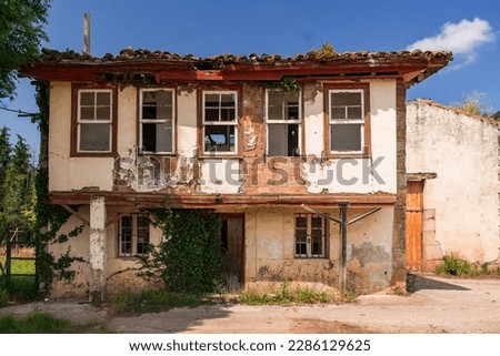 Abandoned house with architecture typical of Mediterranean countries. A view of a non-residential building surrounded by ivy