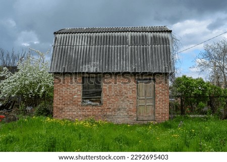 An abandoned house on a garden plot. Country house. An old door in an abandoned house. A window in an old house.