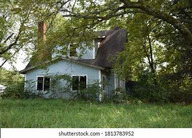 Abandoned house in an overgrown yard - Powered by Shutterstock