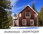 Abandoned house in Scandinavian forest during winter.