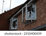 Abandoned house with two open smashed windows UK