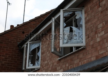 Abandoned house with two open smashed windows UK