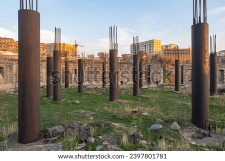 Abandoned house under construction. Columns with protruding reinforcement. Abandoned construction site. Construction has been stopped or frozen. Collapsed walls due to suspension of erection building