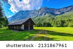 An abandoned hut with a scenic view on mount Dobratsch in the natural park Dobratsch in Villach, Carinthia, Austria. Gailtaler and Villacher Alps. Lush green alpine meadow. Breathing. Remote Location