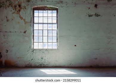 Abandoned Industrial Factory Warehouse Interior. Huge Window To The Floor All Over The Concrete Wall With A Wooden Sill. Grunge Industrial Loft Interior. Brick And Light Background. A Large Window. 