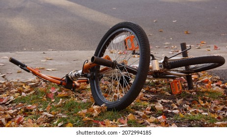 Abandoned Kids Bike On Ground With Dry Leaves. Used Bicycle. Lost And Found Objects. Forgotten Items. - 4 November 2021, Montreal, Canada