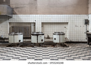 Abandoned large kitchen with 3 large cooking pots and checkerboard pattern tiles - Shutterstock ID 1955243248
