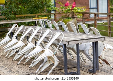 Abandoned Long Conference Table And Stools Outdoors