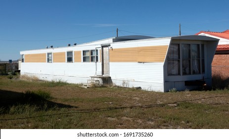 An abandoned mobil home on a blue sky