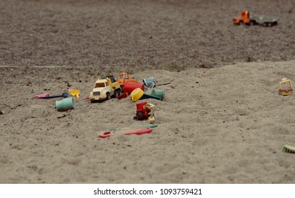 Abandoned old children's toys in the playground with sand