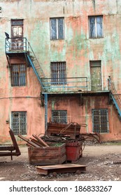 Abandoned Old Abandoned Factory With A Broken Rusty Old Machinery, Equipment And Fixtures . Messy Yard