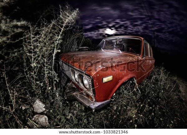 Abandoned old russian car into the dark of the night\
with scary moon