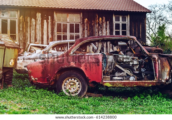 Abandoned\
old rusty body and parts of retro car,\
outdoor