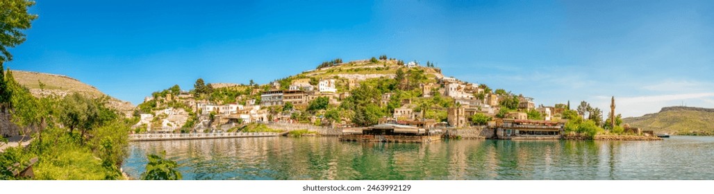 Abandoned old town view in Halfeti Town of Sanliurfa Province. Halfeti village and its submerged minaret and Turkish flags of toursit boats