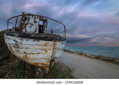 An abandoned old wooden fishing boat on the beach with amazing sky - Shutterstock ID 1234126828