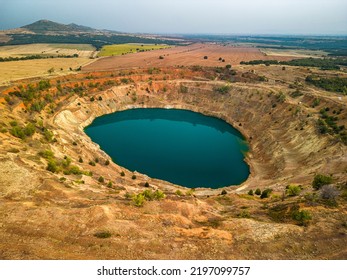 Abandoned ore mining mine with turquoise blue water on the outskirts of Tsar Asen, Bulgaria on sunset - Shutterstock ID 2197099757