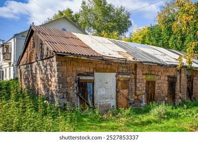 An abandoned outbuilding in the courtyard of an apartment building on an autumn day - Powered by Shutterstock