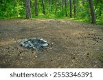 An abandoned place with an old fire pit. A campsite with a prepared fire pit in a forest camp. Old campfire.